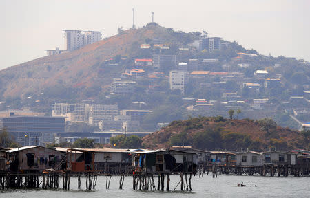 Newly constructed apartment blocks are seen behind the stilt house village called Hanuabada, located in Port Moresby Harbour, Papua New Guinea, November 19, 2018. REUTERS/David Gray