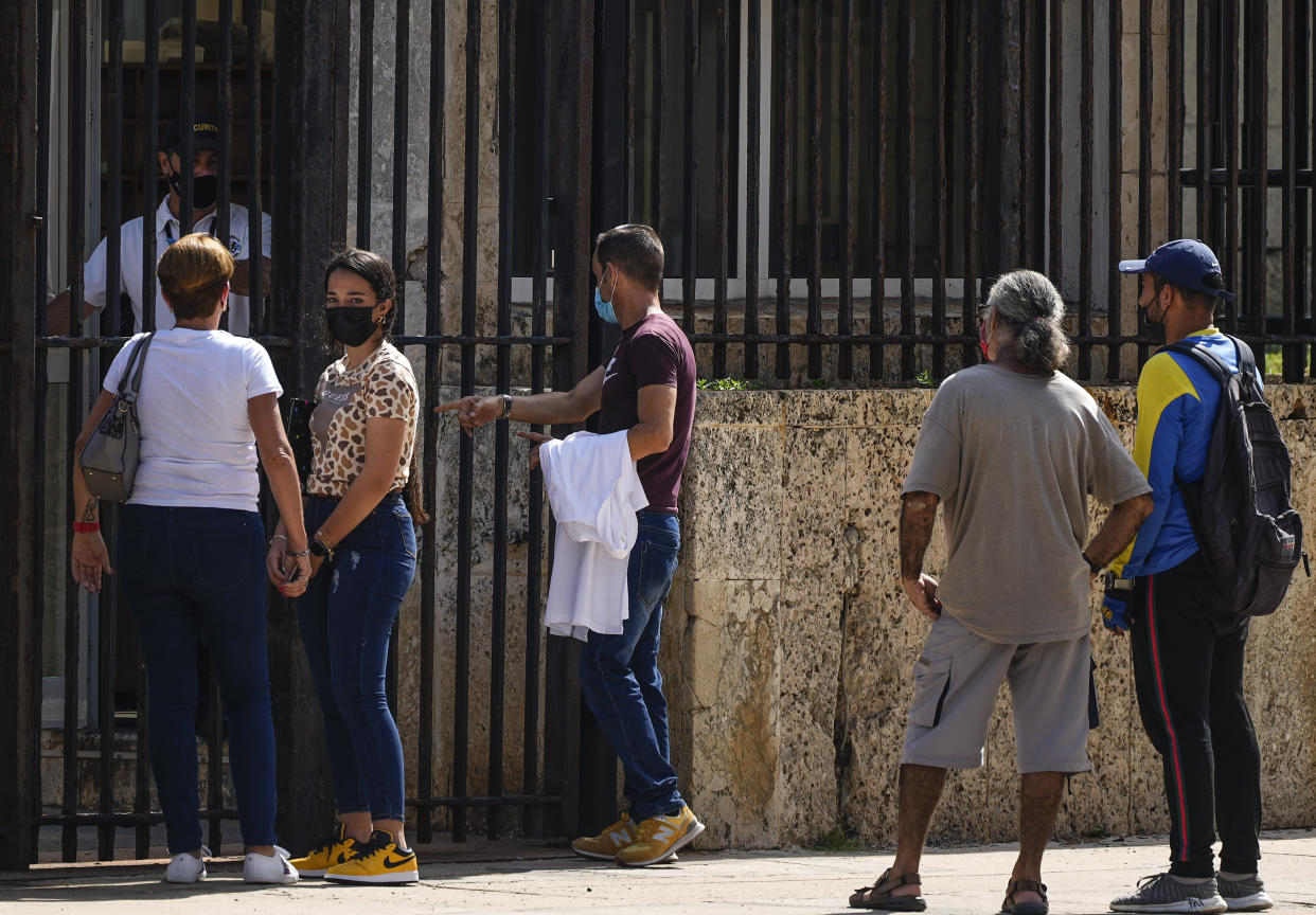 People wait their turns outside the U.S. embassy the day after it reopened its consular services in Havana, Cuba, Wednesday, May 4, 2022. (AP Photo/Ramón Espinosa)