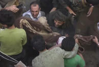 In this frame grab from from video, people carry a child's body after pulling it out from rubble following Saudi-led coalition airstrikes that killed at least six, including four children, officials said, in the residential center of the capital, Sanaa, Yemen, Thursday, May 16, 2019. The Sanaa airstrikes came after Yemen's Iran-backed Houthi rebels, who control the capital, launched a drone attack earlier in the week on a critical oil pipeline in Saudi Arabia, Tehran's biggest rival in the region. (AP Photo)