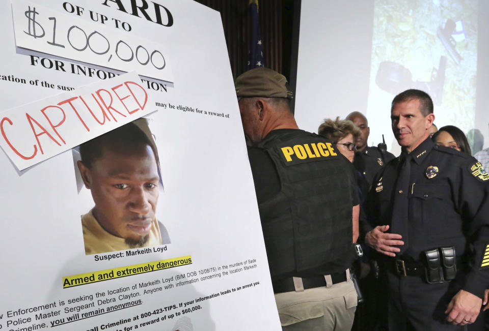 Orlando police Chief John Mina walks past the updated wanted poster of Markeith Loyd during a news conference at Orlando Police Department to announce the capture of Loyd, Tuesday, Jan. 17, 2017, in Orlando, Fla. The suspect in the fatal shooting of an Orlando police officer was captured Tuesday night after eluding a massive manhunt for more than a week, authorities said. (Joe Burbank/Orlando Sentinel via AP)