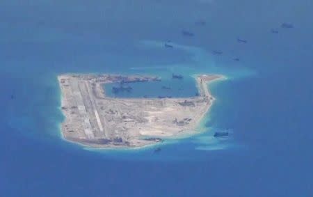 Chinese dredging vessels are purportedly seen in the waters around Fiery Cross Reef in the disputed Spratly Islands in the South China Sea in this still image from video taken by a P-8A Poseidon surveillance aircraft provided by the United States Navy May 21, 2015. U.S. Navy/Handout via Reuters/File Photo