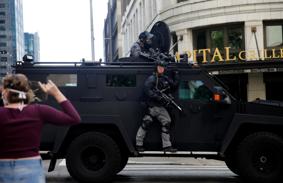 Seattle police drive by protesters in an armored vehicle during aprotest against the death in Minneapolis police custody of George Floyd, in Seattle, Washington, U.S. May 31, 2020. REUTERS/Lindsey Wasson