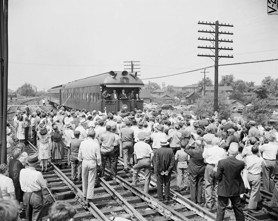 FILE - President Harry S. Truman steps out onto the rear platform of his special train to greet a crowd that gathered when his whistle-stop tour paused briefly in Crestline, Ohio, June 4, 1948. Truman, at center, in front of microphone, predicted that Democratic candidate Frank J. Lausche, extreme left, would be elected governor of Ohio. (AP Photo/Harold Valentine, File)