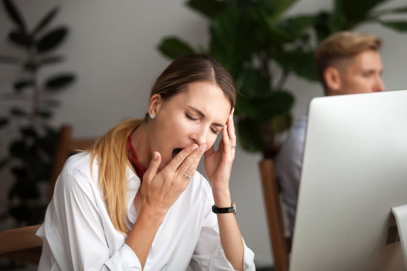 Bored businesswoman yawning at workplace feeling no motivation or lack of sleep tired of boring office routine, exhausted restless employee gaping suffering from chronic fatigue or overwork concept