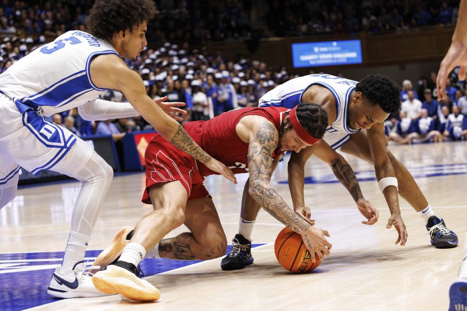 Louisville's Tre White and Duke's Jeremy Roach, right, and Tyrese Proctor vie for the ball during the first half of an NCAA college basketball game in Durham, N.C., Wednesday, Feb. 28, 2024. (AP Photo/Ben McKeown)