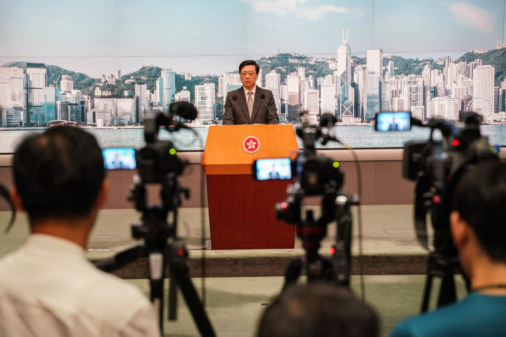 Journalists take videos while John Lee speaks during the