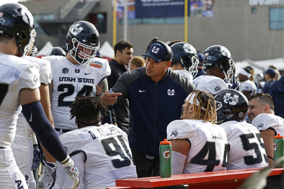 Utah State interim head coach Frank Maile, center, speaks to his players during a time out in the first half of the New Mexico Bowl NCAA college football game against North Texas in Albuquerque, N.M., Saturday, Dec. 15, 2018. (AP Photo/Andres Leighton)