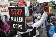 Demonstranten halten bei einer Protestkundgebung gegen Rassismus und Polizeigewalt in der informellen Siedlung Mathare-Slum Schilder mit Protestparolen hoch. Foto: Khalil Senosi / AP / dpa