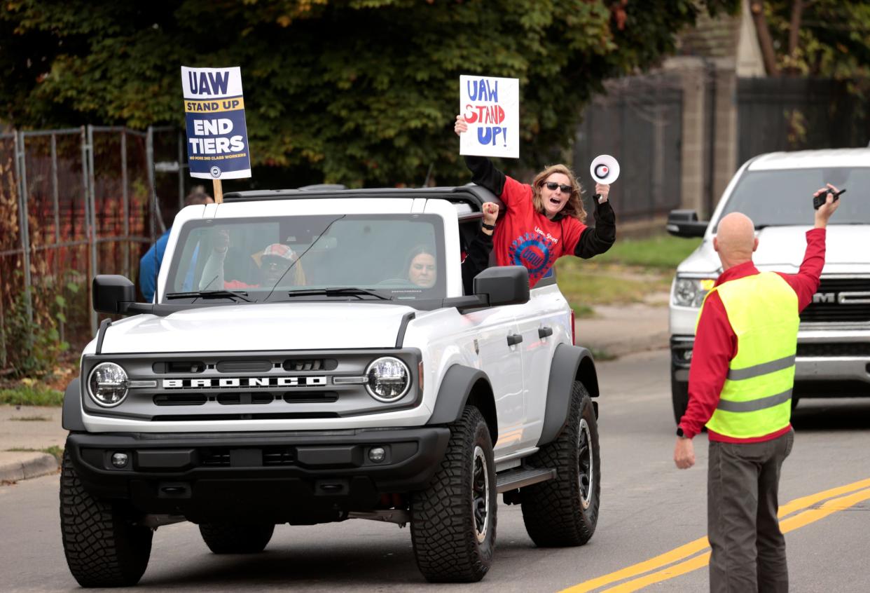 Amanda Robbins, 38, of Romulus, who works the frame line at the Ford Michigan Assembly plant in Wayne, leans out of a Ford Bronco as a caravan of SUVs head down Van Dyke and into the entrance of the UAW Solidarity House on Jefferson Avenue in Detroit on Sept. 29, 2023, for a rally. UAW President Shawn Fain spoke to the crowd of strikers at the parking lot of the headquarters.