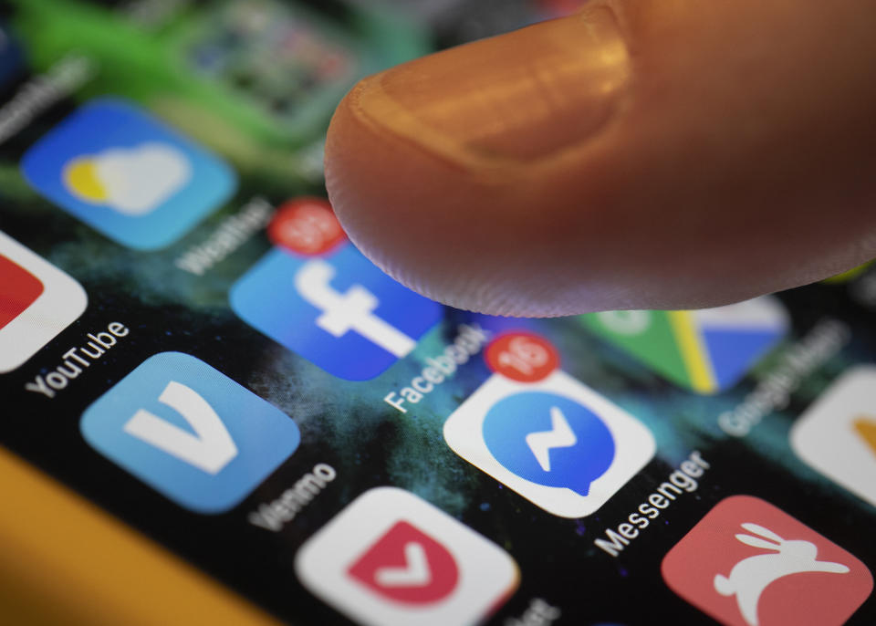 FILE - An iPhone displays the apps for Facebook and Messenger in New Orleans, Aug. 11, 2019. Online companies would have to ramp up efforts to keep harmful content off their platforms and take other steps to protect users under rules that European Union lawmakers are set to vote on Thursday Jan. 20, 2022. (AP Photo/Jenny Kane, File)