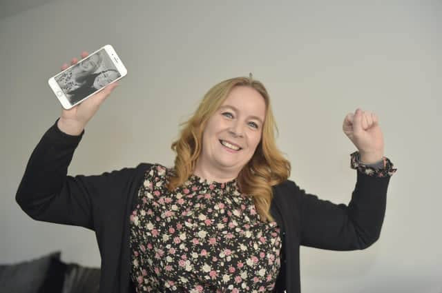 Clare Atfield, 39, and her iPhone that spent 460 days underwater. (SWNS)