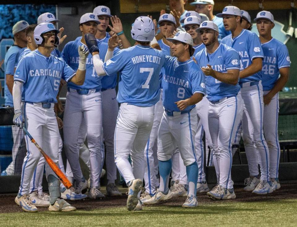 North Carolina’s Vance Honeycutt (7) greeted by his teammates after scoring on an RBI by Parks Harber to take a 2-0 lead in the third inning against West Virginia during the NCAA Super Regional on Saturday, June 8, 2024 at Boshamer Stadium in Chapel Hill, N.C.