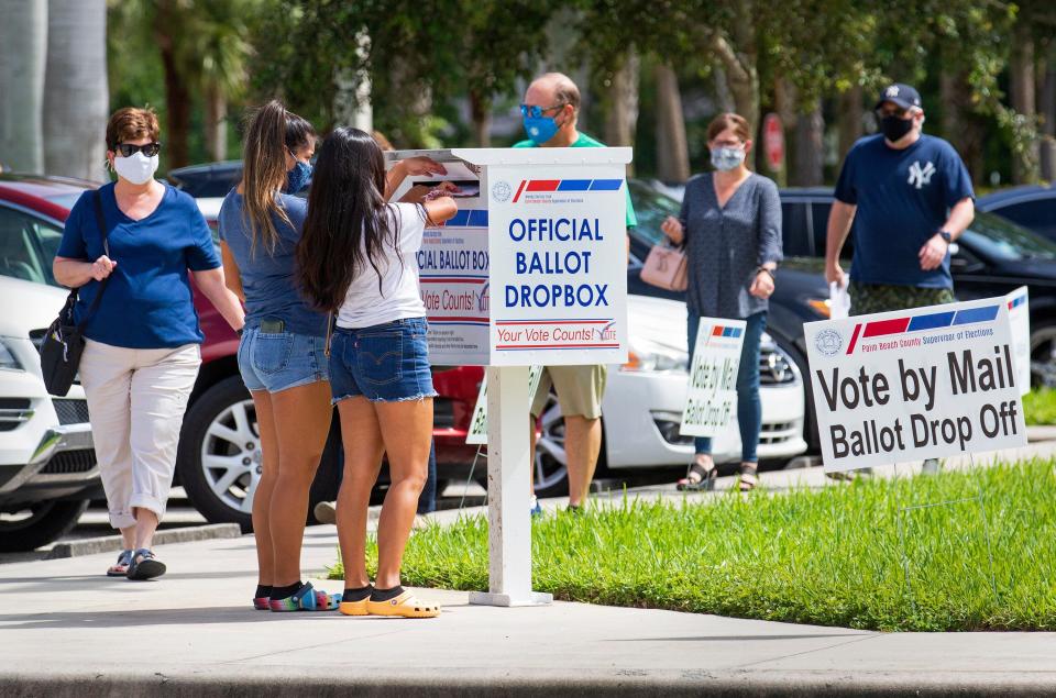 Two women cast their vote-by-mail ballots at a dropbox as voters flock to the Palm Beach County Supervisor of Elections main office in West Palm Beach in 2020.