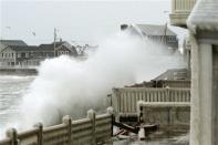 Waves crash into houses on Lighthouse Road during a winter nor'easter snow storm in Scituate, Massachusetts January 3, 2014. REUTERS/Dominick Reuter