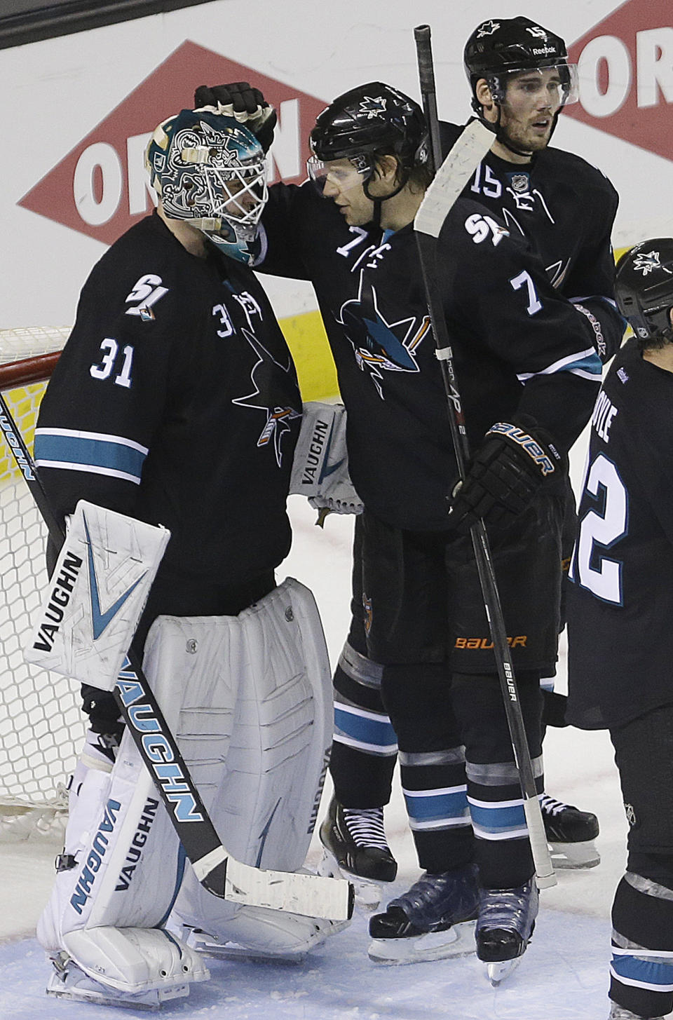 San Jose Sharks goalie Antti Niemi, left, is congratulated by Brad Stuart (7) and James Sheppard (15) at the end of Game 1 of an NHL hockey first-round playoff series Thursday, April 17, 2014, in San Jose, Calif. San Jose won, 6-3. (AP Photo/Ben Margot)