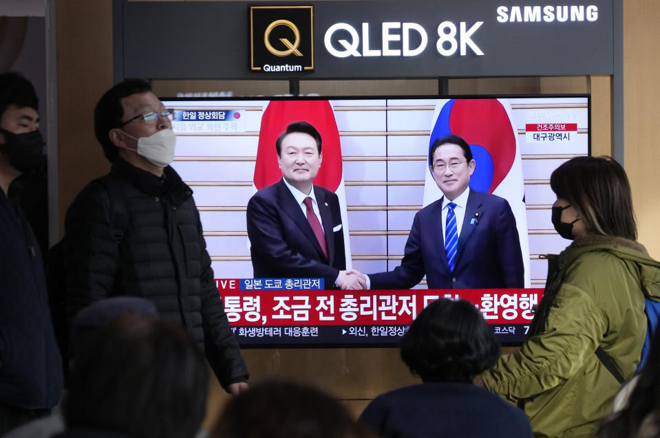 People pass by a TV screen showing South Korean President Yoon Suk Yeol, left, meeting with Japanese Prime Minister Fumio Kishida in Japan, during a news program at the Seoul Railway Station in Seoul, South Korea, Thursday, March 16, 2023. Japan and South Korea agreed on steps toward resolving a trade dispute that has been one of the strains the nations' leaders aimed to resolve at a highly anticipated summit Thursday. (AP Photo/Ahn Young-joon)