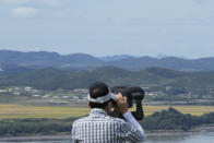 A visitor watches the North Korea side from the Unification Observation Post in Paju, South Korea, near the border with North Korea, Sunday, Sept. 26, 2021. The powerful sister of North Korean leader Kim Jong Un said Saturday that her country will take steps to repair ties with South Korea, and may even discuss another summit between their leaders, if the South drops what she described as hostility and double standards. (AP Photo/Ahn Young-joon)