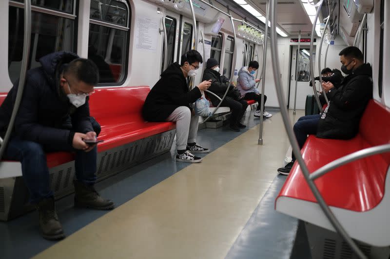 People wearing face masks travel in the subway, as the country is hit by an outbreak of the new coronavirus, in Beijing