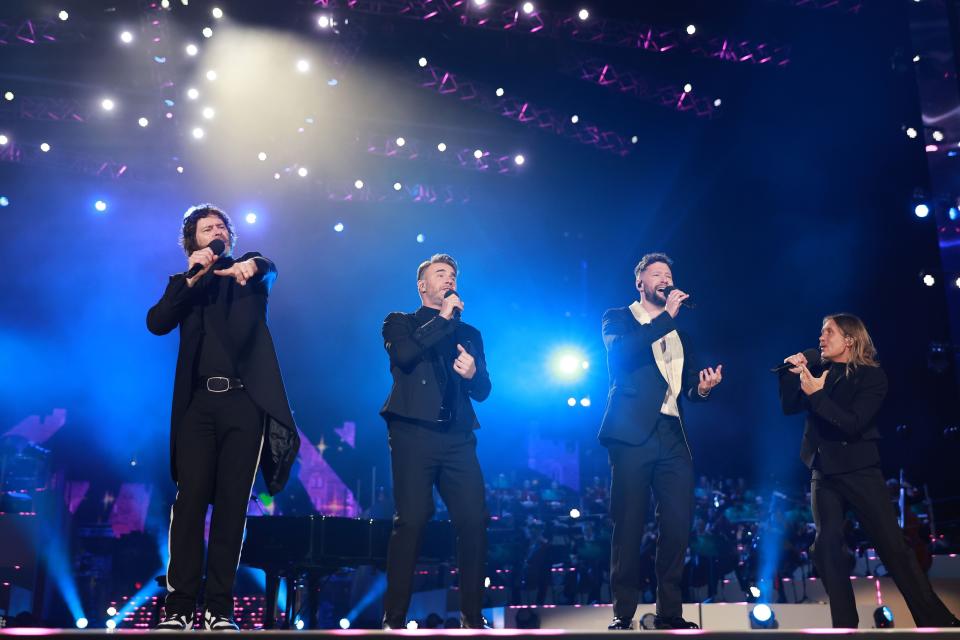 Gary Barlow, Howard Donald and Mark Owen of Take That and Calum Scott perform on stage during the Coronation Concert on May 07, 2023 in Windsor, England.