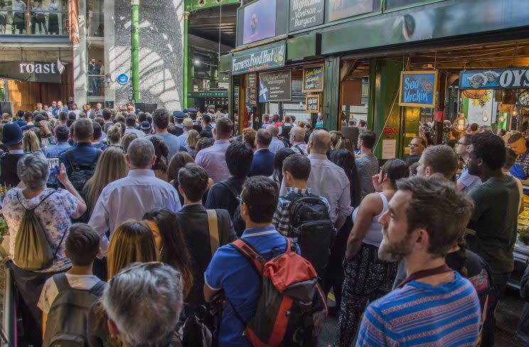 Sombre market visitors mark a minute’s silence at Borough Market on Wednesday. (Rex)