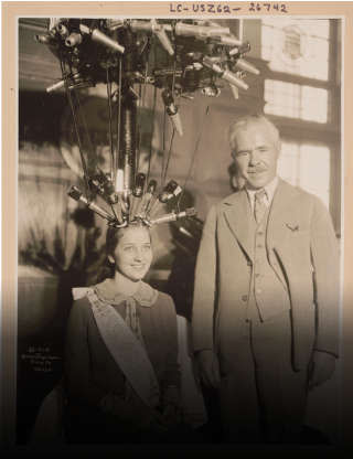 Norma Smallwood, Miss America 1926, se fait faire une permanente. À droite, Karl Nessler, qui a inventé la machine à permanente en 1906.. PHOTO LIBRARY OF CONGRESS