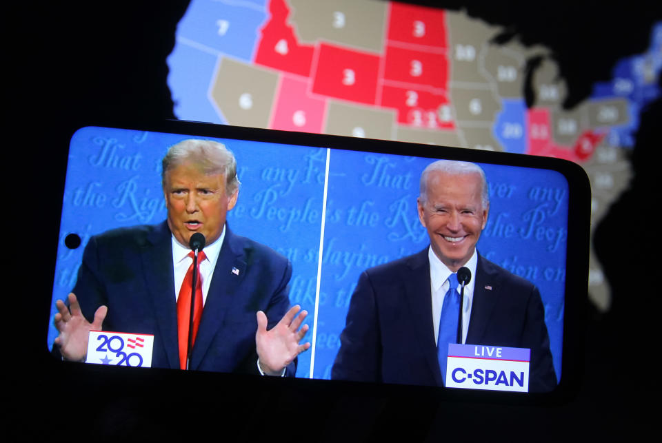 A split screen showing footage of Donald Trump and Joe Biden on a smartphone during a presidential debate in Nashville in 2020.