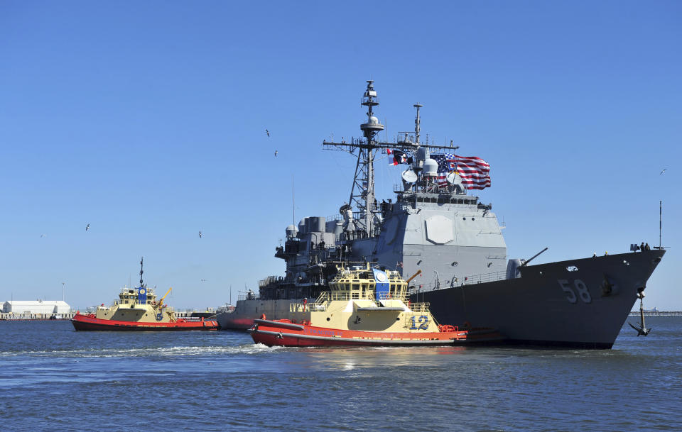 In this Feb. 15, 2014, photo released by the U.S. Navy, the guided-missile cruiser USS Philippine Sea leaves Naval Station Mayport in Mayport, Florida. Two U.S. Navy warships operating in the Mideast have been affected by the coronavirus, authorities said Friday, Feb. 26, 2021, with one already at port in Bahrain and another heading to port. The Philippine Sea will head to a port that the Navy declined to name over "operational security." (Mass Communication Specialist 2nd Class Marcus L. Stanley/U.S. Navy, via AP)