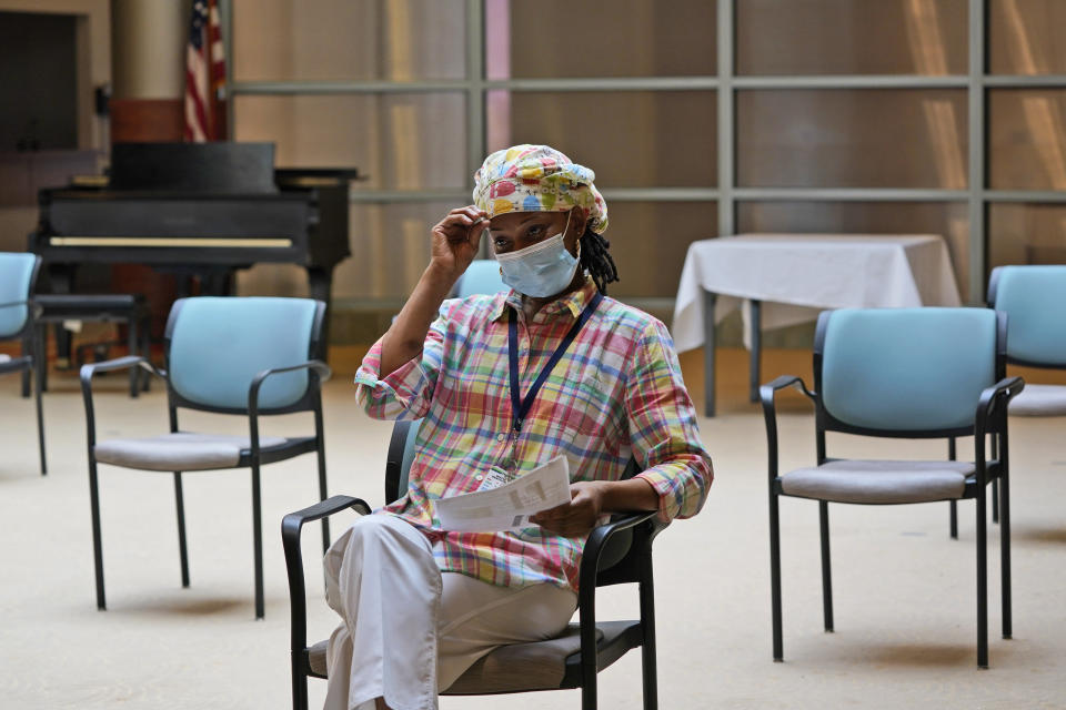 Shyrel Ritter, a certified nursing assistant at the Hebrew Home at Riverdale, waits to receive her COVID-19 booster shot at her workplace in New York, Monday, Sept. 27, 2021. The deadline for hospital and nursing home workers in New York state to be vaccinated against COVID-19 arrived Monday with the prospect of severe staff shortages fueled by workers getting suspended or fired for refusing to be inoculated. All health care workers in New York state at hospitals and nursing homes are required to be vaccinated with at least one dose of the COVID-19 vaccine by Monday. (AP Photo/Seth Wenig)