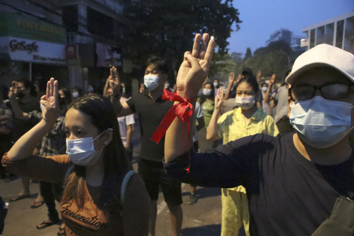 Anti-coup protesters flash three-fingered gesture, a symbol of resistance, during a rally outside their homes in downtown Yangon, Myanmar, Monday morning, March 22, 2021. (AP Photo)
