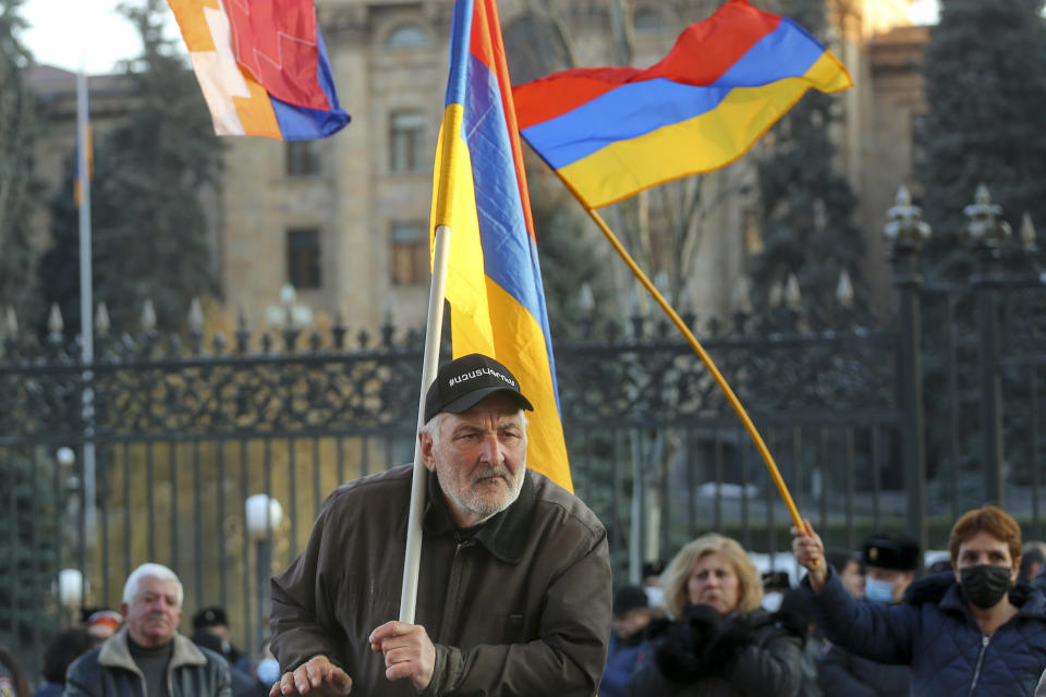 Opposition demonstrators, some of them with Armenian national flags rally to pressure Armenian Prime Minister Nikol Pashinyan to resign in Yerevan, Armenia, Wednesday, March 3, 2021. Thousands of opposition supporters are rallying in the Armenian capital to demand the resignation of the country's prime minister amid a heavy presence of security forces. Prime Minister Nikol Pashinyan has faced the opposition demands to step down since he signed a peace deal that ended six weeks of fighting over the Nagorno-Karabakh region, in which Azerbaijan routed the Armenian forces. (Hrant Khachatryan/PAN Photo via AP)