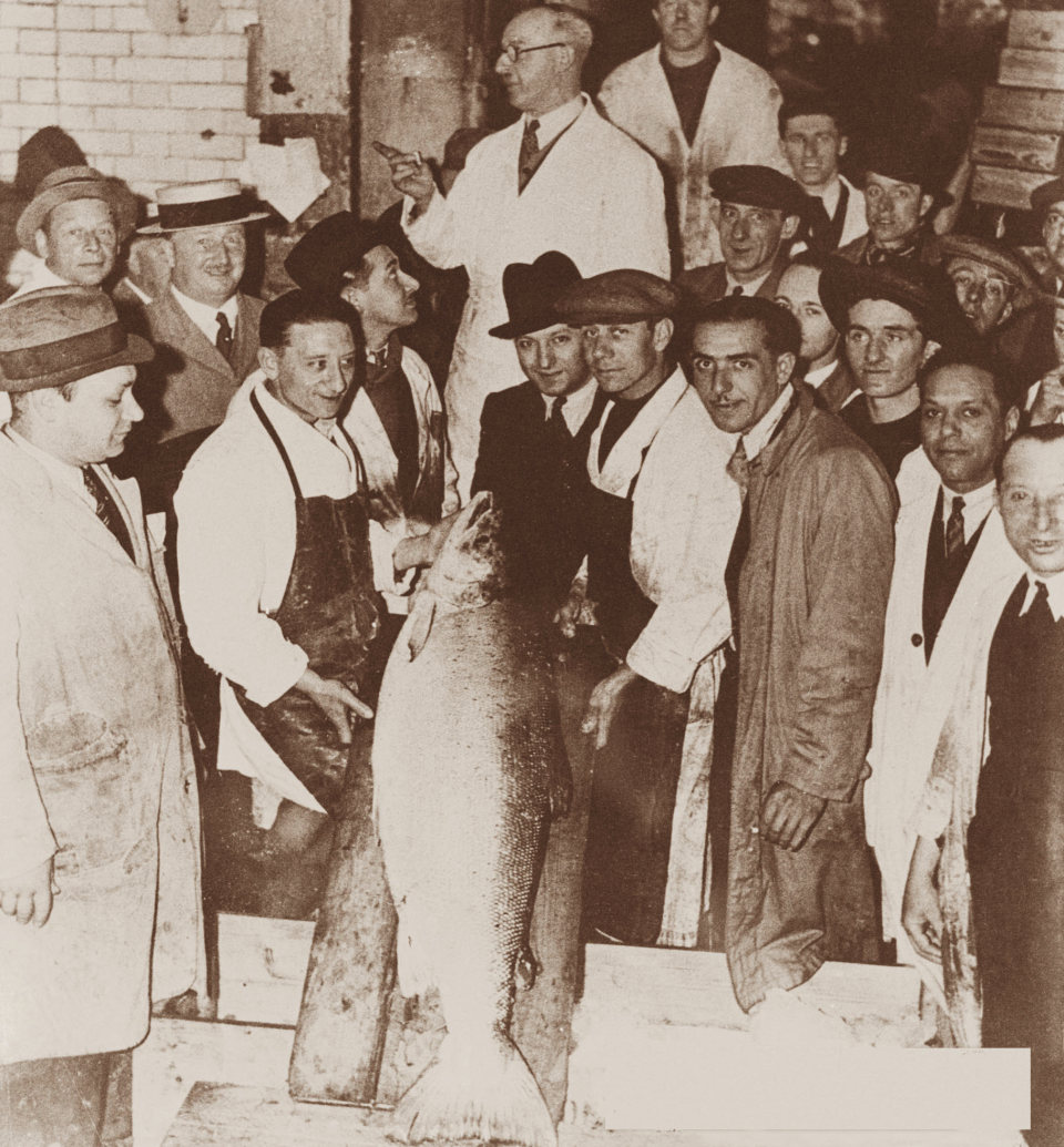 In this 1934 photo provided by H. Forman & Son, Louis Forman, center, Lance Forman's grandfather poses with the large wild salmon caught at that time, at Billingsgate Market in London. "We smoked that and sold it to Selfridges". Forman's family has been producing traditional smoked salmon in London for four generations and supply so of London's finest restaurants, hotel and stores. (H. Forman & Son via AP)