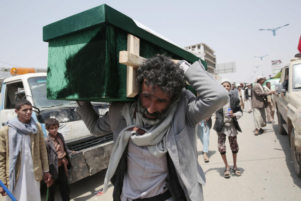 A Yemeni man carries the coffin of a victim of a Saudi-led airstrike, during a funeral in Saada, Yemen, Monday, Aug. 13, 2018. Yemen's shiite rebels are backing a United Nations' call for an investigation into the airstrike in the country's north that killed dozens of people including many children. (AP Photo/Hani Mohammed)