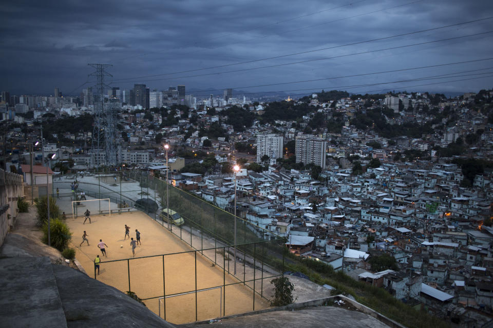 In this March 7, 2014 photo, boys play soccer in the Sao Carlos slum after sunset in Rio de Janeiro, Brazil. The first thing Brazilian kids often do before pick-up games is play “rock, scissors, paper” to decide who will be goalkeeper. With so many outstanding strikers and midfielders in Brazilian history, few chose goalkeepers as their childhood idols. (AP Photo/Felipe Dana)
