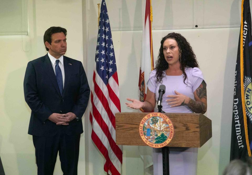 Gov. Ron DeSantis listens Thursday to remarks from one of Jeffrey Epstein's victims, Haley Robson, inside the Palm Beach Police Department just before he signed a bill meant to release secret documents detailing the proceedings of a 2006 Palm Beach County grand jury that issued only one criminal prostitution-related charge against Epstein despite police uncovering dozens of victims.