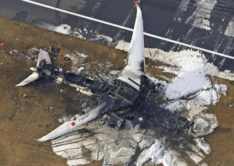 This aerial photo show the burn-out Japan Airlines plane at Haneda airport on Wednesday, Jan. 3, 2024, in Tokyo, Japan. The large passenger plane and a Japanese coast guard aircraft collided on the runway at Tokyo's Haneda Airport on Tuesday and burst into flames, killing several people aboard the coast guard plane, officials said. (Kyodo News via AP)