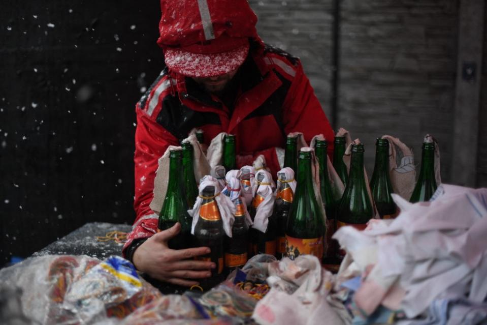 <p>Cet Ukrainien est en pleine préparation de cocktails molotov, à Lviv. Au 26 février, près de 200 civils ukrainiens avaient été tués dans le conflit. (Daniel LEAL / AFP)</p> 