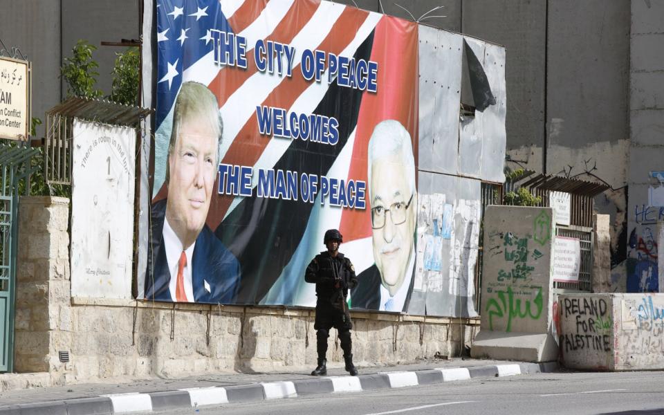 A Palestinian security official takes position before the arrival of US President Donald J. Trump's convoy in Bethlehem - Credit: EPA/ALAA BADARNEH