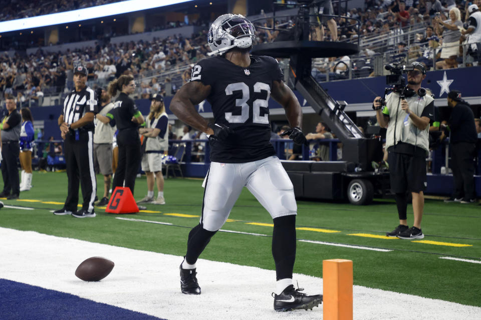 Las Vegas Raiders running back Damien Williams (32) celebrates scoring on a running play in the first half of a preseason NFL football game against the Dallas Cowboys in Arlington, Texas, Saturday, Aug. 26, 2023. (AP Photo/Michael Ainsworth)