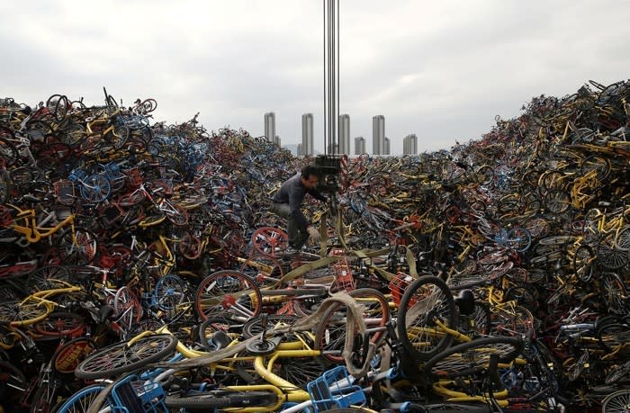 A man works on top of a heap of bicycles in Xiamen, China, on December 13, 2017, in this Reuters photo. Last year, China’s booming bike-share industry created a massive oversupply, resulting in piles of discarded and impounded bikes across the country. <a href="https://www.theatlantic.com/photo/2018/03/bike-share-oversupply-in-china-huge-piles-of-abandoned-and-broken-bicycles/556268/" rel="nofollow noopener" target="_blank" data-ylk="slk:See more photos.;elm:context_link;itc:0;sec:content-canvas" class="link ">See more photos.</a>