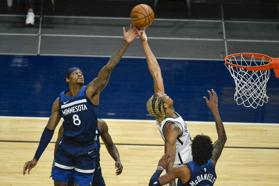 Minnesota Timberwolves forward Jarred Vanderbilt (8) and Brooklyn Nets forward Nicolas Claxton reach for a rebound during the first half of an NBA basketball game Tuesday, April 13, 2021, in Minneapolis. (AP Photo/Craig Lassig)