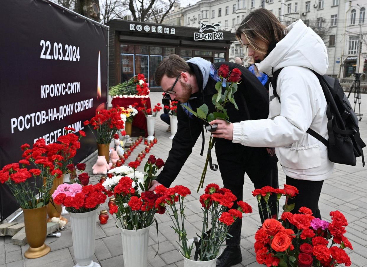 PHOTO: People place flowers at a makeshift memorial to the victims of a shooting attack at the Crocus City Hall concert venue outside Moscow, in Rostov-on-Don, Russia, on March 23, 2024. The banner reads: ' Crocus City, Rostov-on-Don mourns with you.'  (Sergey Pivovarov/Reuters)