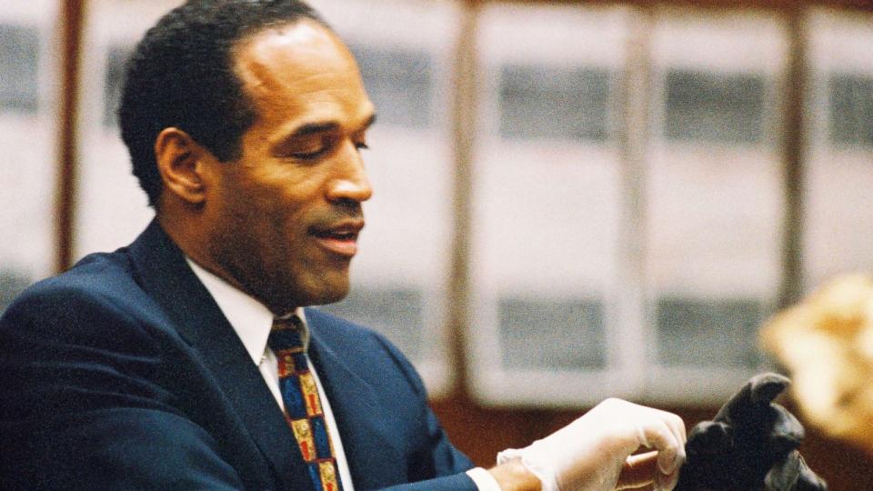 PHOTO: O.J. Simpson tries on a leather glove allegedly used in the murders of Nicole Brown Simpson and Ronald Goldman during testimony in Simpson's murder trial June 15, 1995 in Los Angeles. (Lee Celano/Getty Images)