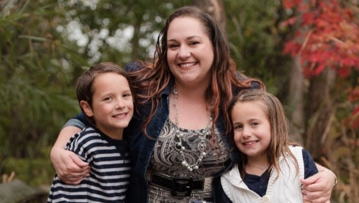 a woman holds onto her two children outside