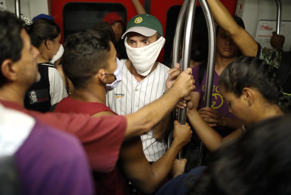 A man wears a hand towel as a makeshift protective mask, while riding on the subway in Caracas, Venezuela, Friday, March 13, 2020. Venezuela's Vice President Delcy Rodríguez confirmed Friday the first two cases of the new coronavirus in the South American country. The vast majority of people recover from the new virus. (AP Photo/Ariana Cubillos)