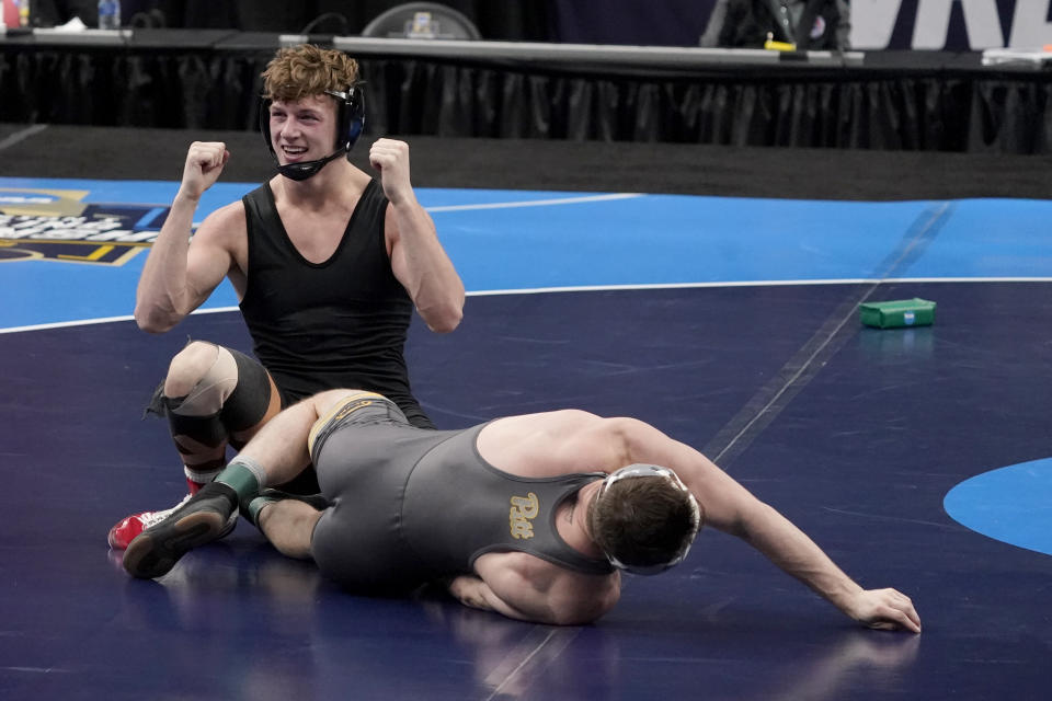 FILE - Stanford's Shane Griffith celebrates after defeating Pittsburgh's Jake Wentzel during their 165-pound match in the finals of the NCAA wrestling championships in St. Louis, in this Saturday, March 20, 2021, file photo. Griffith wore a black singlet minus the Stanford logo as a statement after the school announced in July that wrestling and 10 other sports, most of them that produce athletes for the U.S. Olympic team, would be dropped to save money. (AP Photo/Jeff Roberson, File)