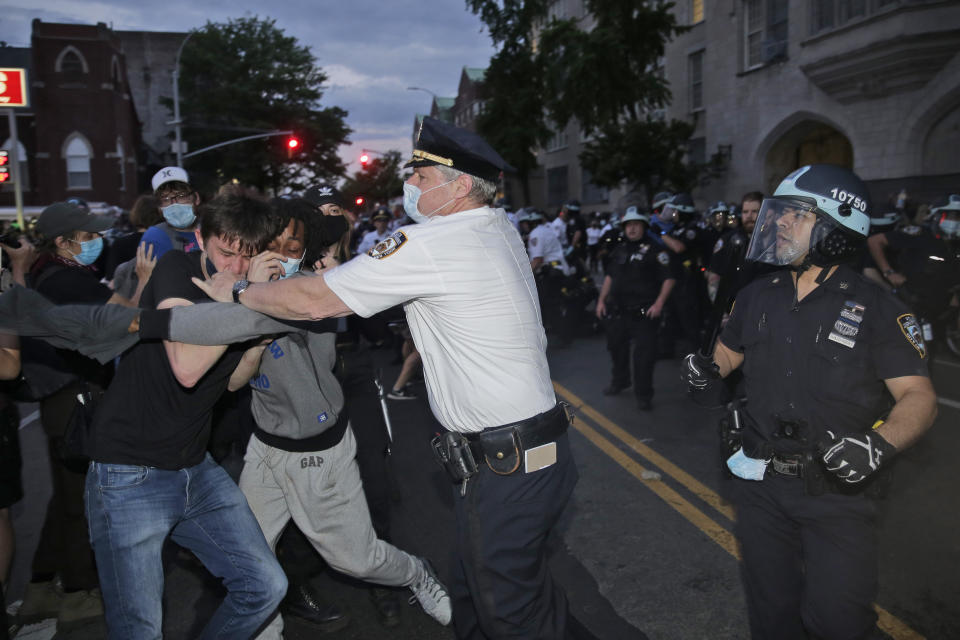 FILE - In this May 30, 2020, file photo, police scuffle with protesters in the Brooklyn borough of New York. Two civil rights organizations are suing the New York Police Department on behalf of protesters who say they were roughed up by officers because they expressed anti-police views during nightly demonstrations in the spring in the wake of George Floyd's killing. (AP Photo/Seth Wenig, File)