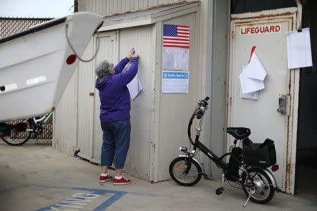 A polling station worker puts up signs for the primary election at a polling station in Venice, Los Angeles, California, U.S. June 5, 2018. REUTERS/Lucy Nicholson