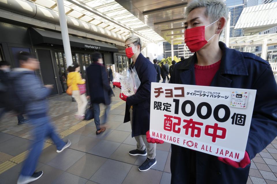 LGBTQ activists distribute chocolates to morning commuters at Shinagawa Station, marking the fifth anniversary of the day a group of plaintiffs launched their legal battle to achieve the marriage equality, to bolster the momentum toward pushing the government to provide the protection Wednesday, Feb. 14, 2024, in Tokyo. The banner reads: "We are distributing chocolates, limited to 1000 pieces." (AP Photo/Eugene Hoshiko)