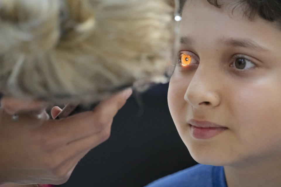 A boy undergoes an eyesight examination performed by volunteer ophthalmologists, in Nucsoara, Romania, Saturday, May 29, 2021. Dozens of disadvantaged young Romanian children got a chance to get their eyesight examined for the first time in their lives during an event arranged by humanitarian organization Casa Buna, or Good House, which has played a prominent role in supporting the local children's lives throughout the pandemic. (AP Photo/Vadim Ghirda)