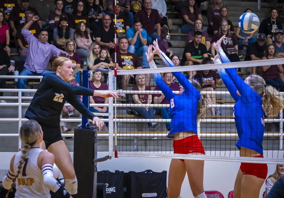 Dripping Springs outside hitter Henley Anderson, left, crushes the ball for a kill past Westlake blockers during the third set of the Tigers' regional quarterfinal sweep Tuesday night at Burger Center. Dripping Springs, the defending Class 6A state champion, will play in this weekend's regional tournament.